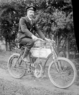 Man_wearing_cap_&amp;_suit_on_motorised_pushbike,_Mt_Buffalo_Vic,_Alice_Manfield